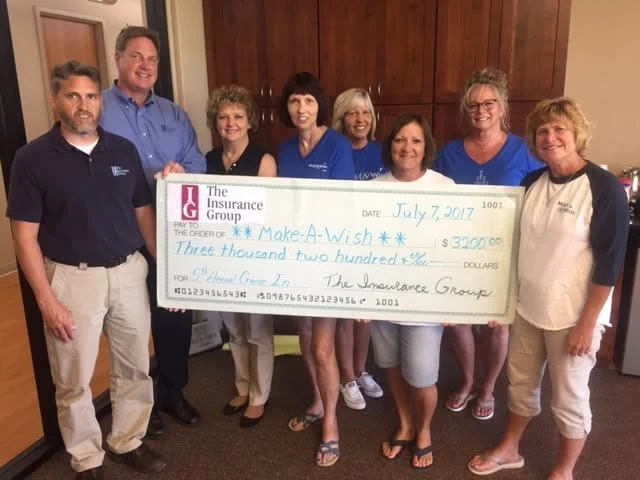 The Insurance Group team presenting a donation check to Make-A-Wish